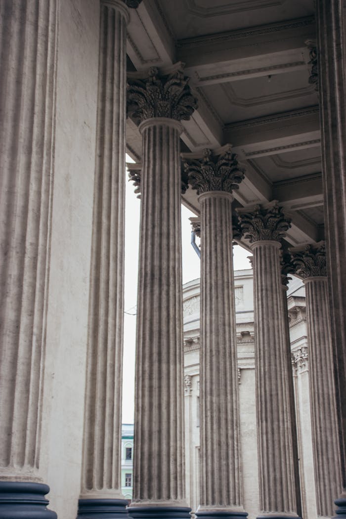 Vertical shot of classic stone columns in Saint Petersburg, showcasing intricate carvings.